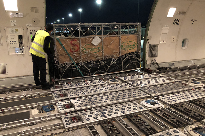 crates lifted into airplane with forklift